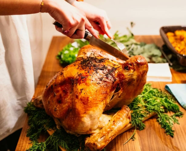 Carving roasted turkey on serving tray