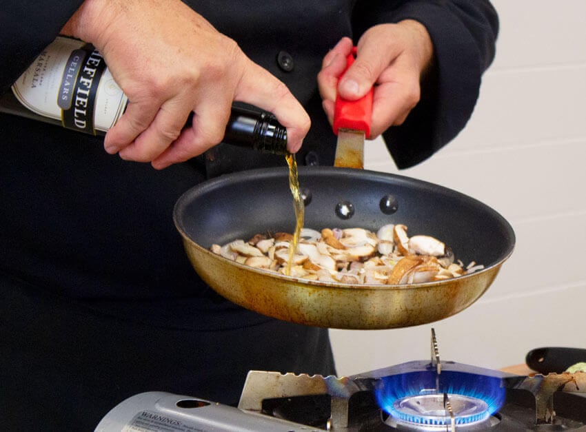 Pouring Marsala wine for mushroom sauce