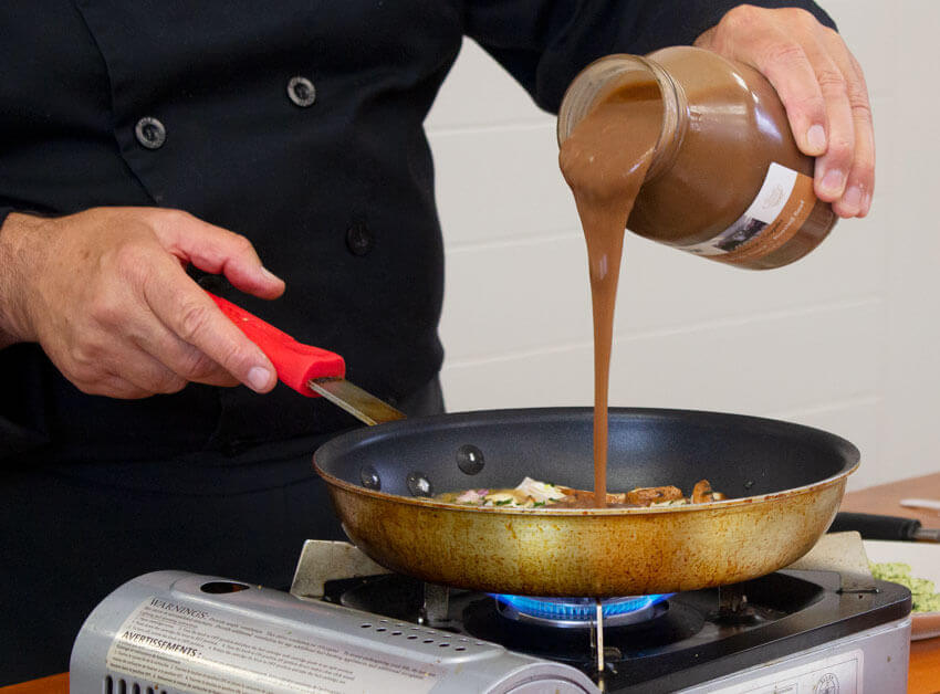 Chef adds espanole sauce to mushrooms