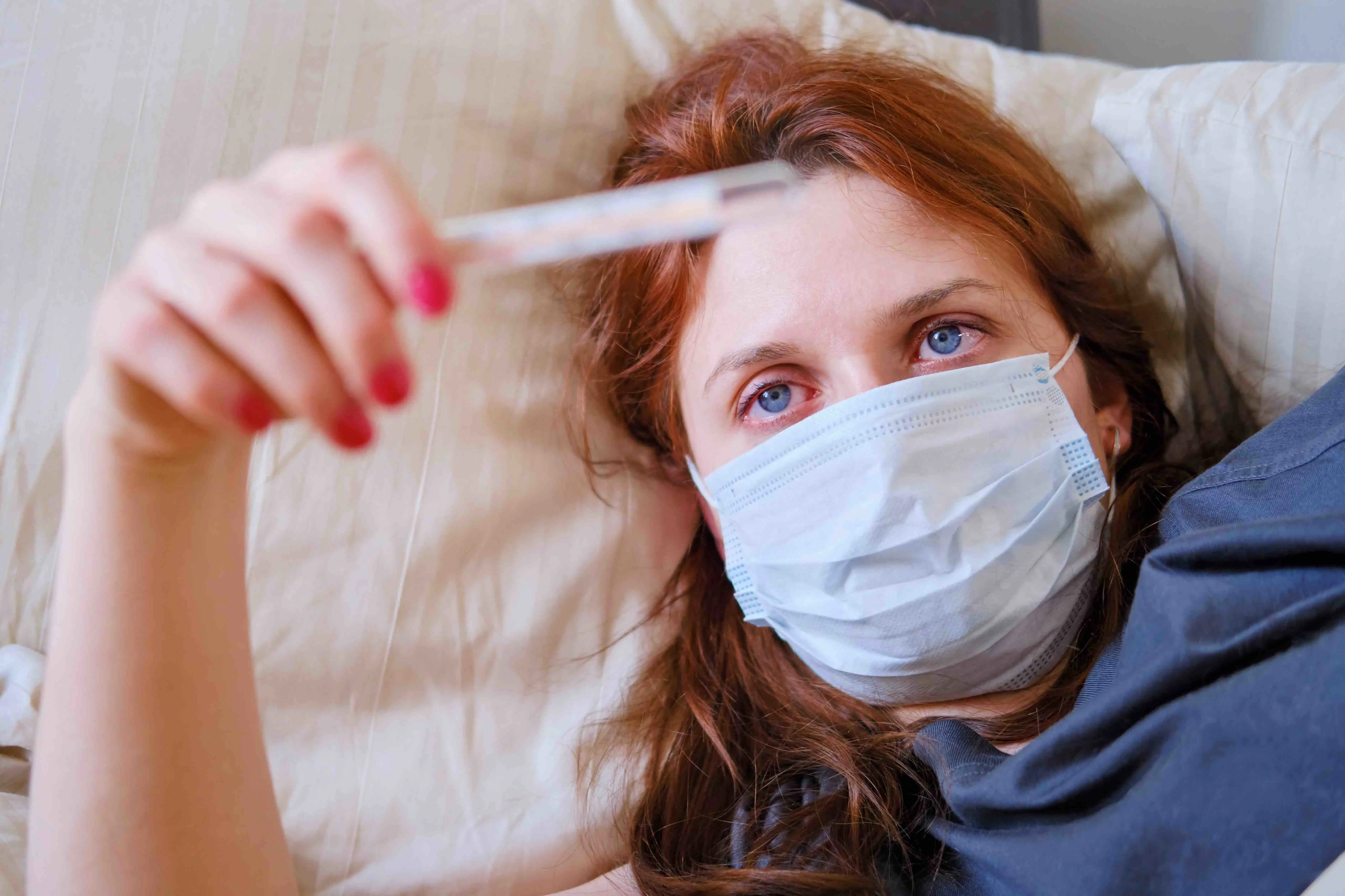 Woman checking temperature with thermometer