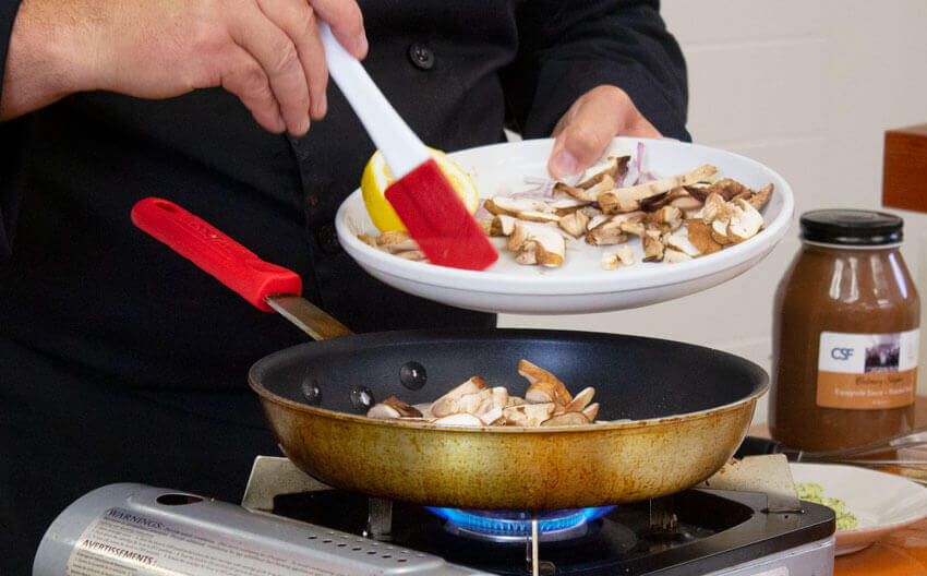 Cooking sliced shiitake mushrooms in pan