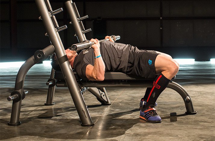 Man performing bench press at 90-degrees