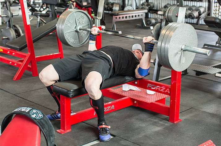 Man bench pressing barbell powerlifting style