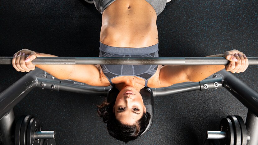 Woman performing barbell bench press