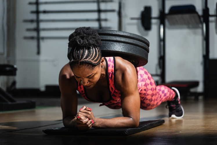 Woman weighted planking exercise