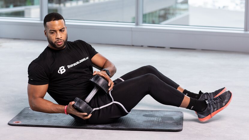 Man doing Russian twists on mat