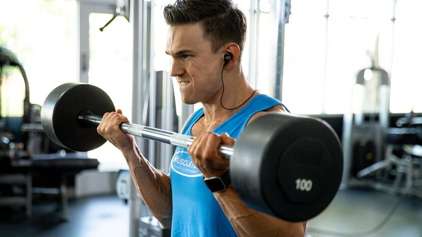 Man performing standing barbell curl