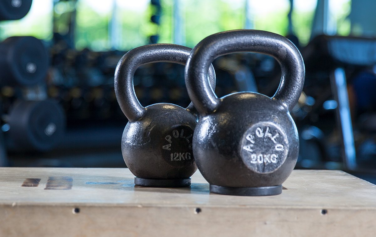 Two kettlebells on wooden platform