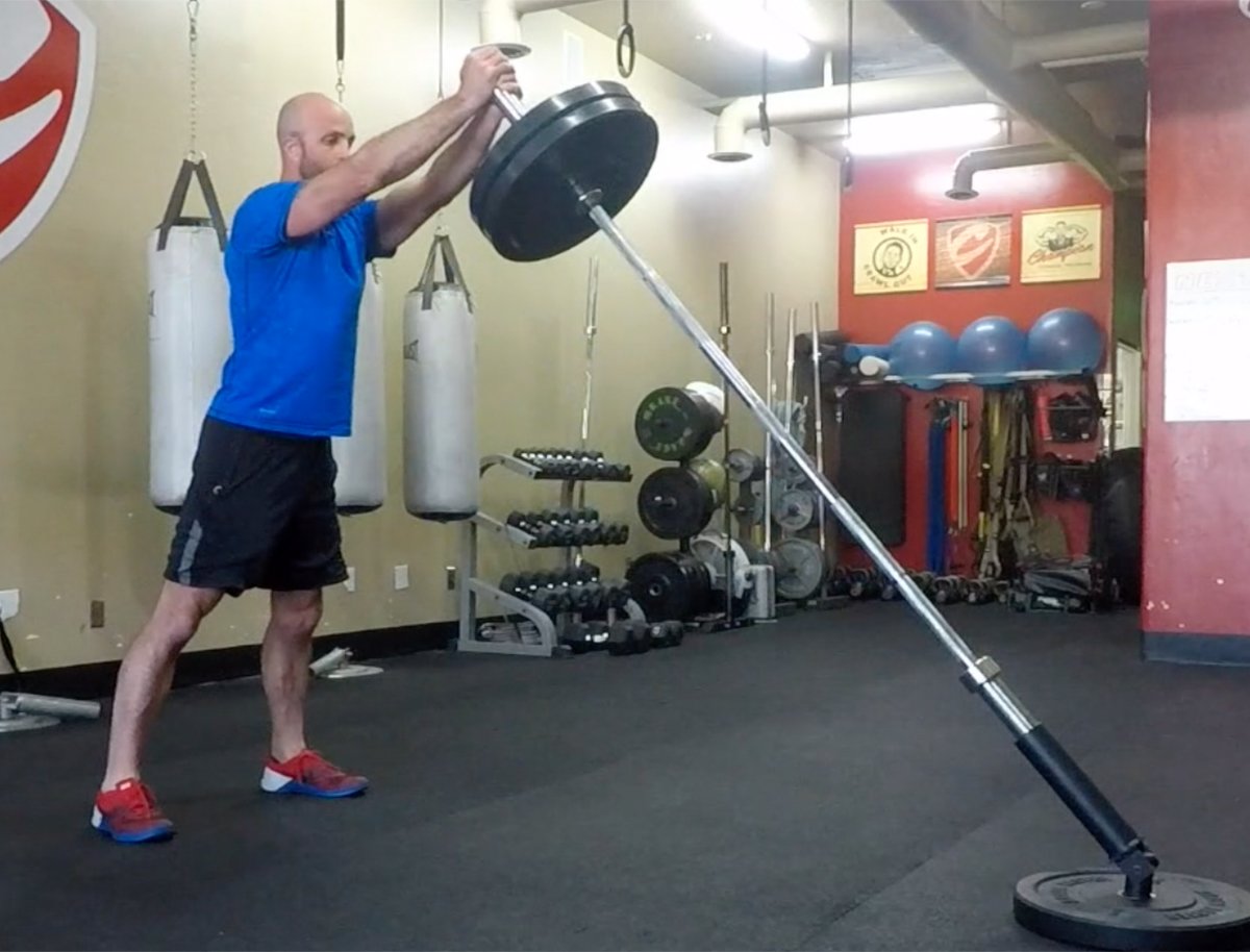 Man performs landmine exercise in gym