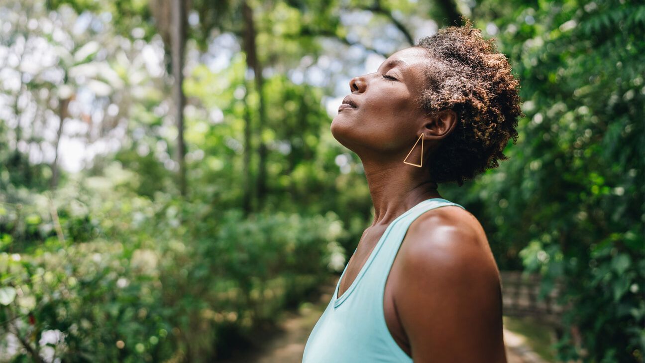 Woman taking deep breath in nature