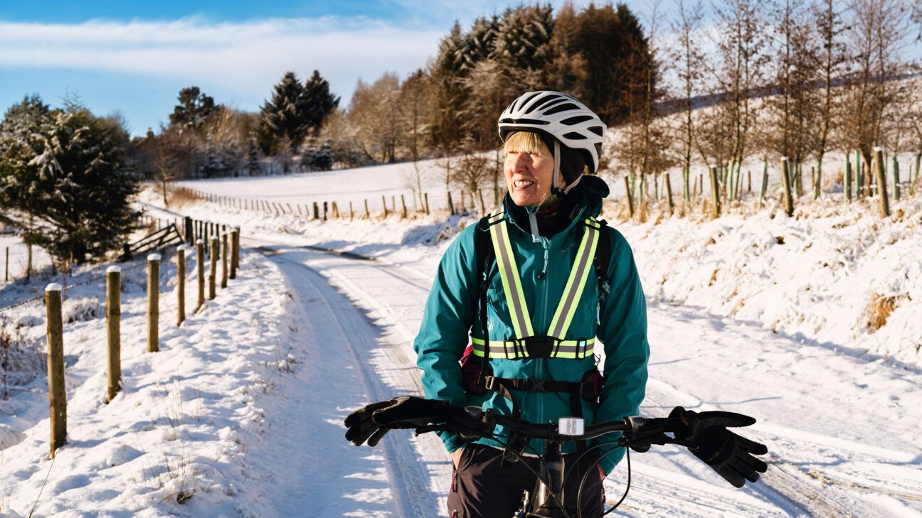 Woman cycling in winter snow