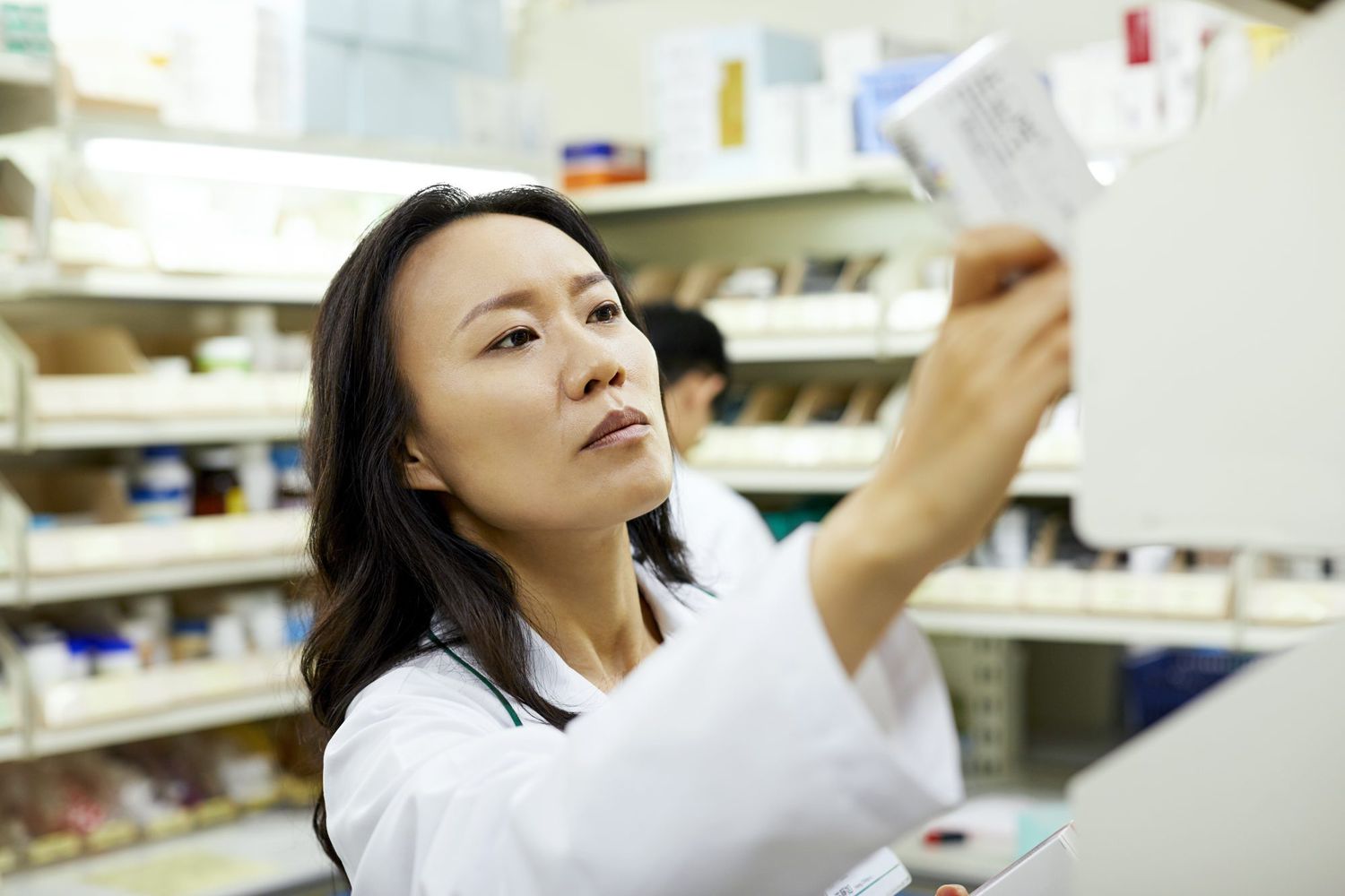 Pharmacist examining pill bottle label