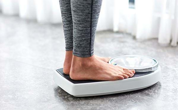 Person weighing themselves on bathroom scale