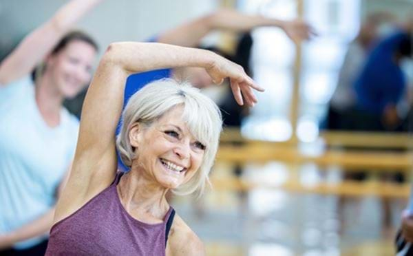 Mature woman smiling in gym attire