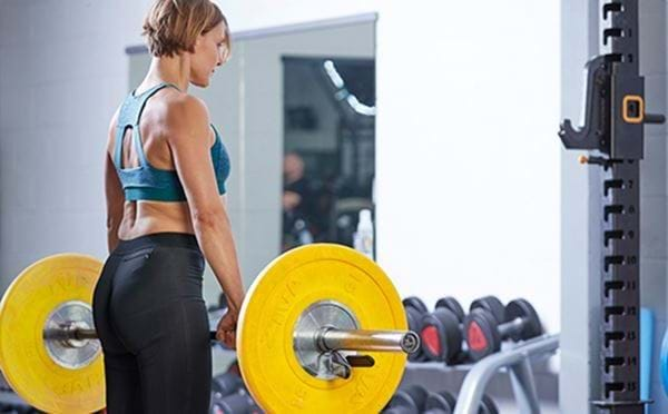 Woman performing barbell squat exercise