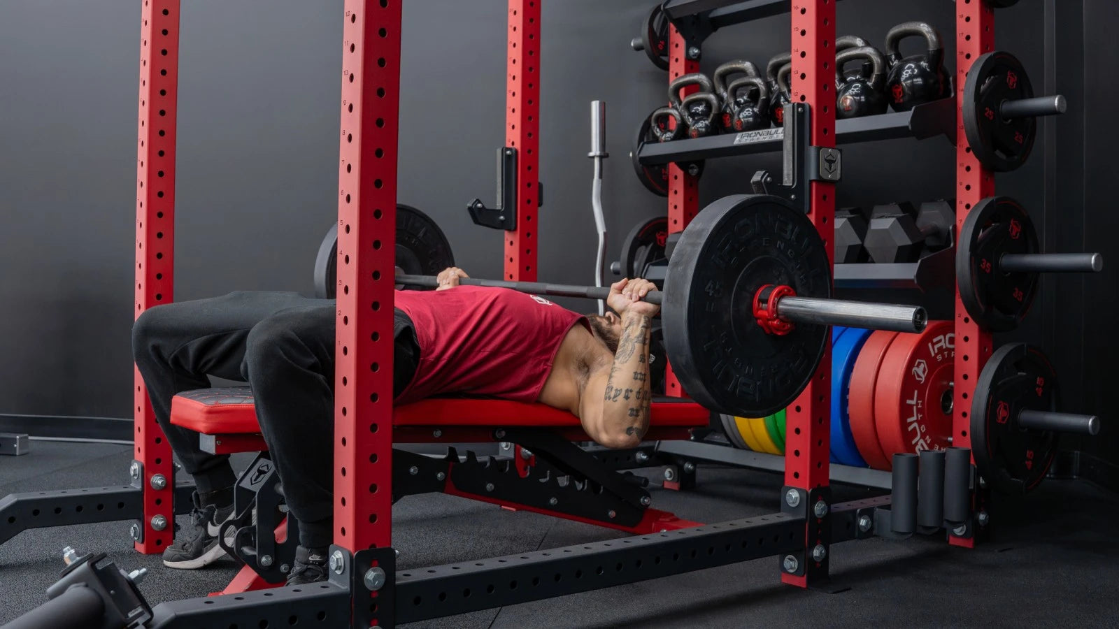 Man performing bench press in rack