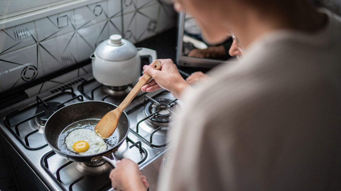 Person cooking eggs on stovetop