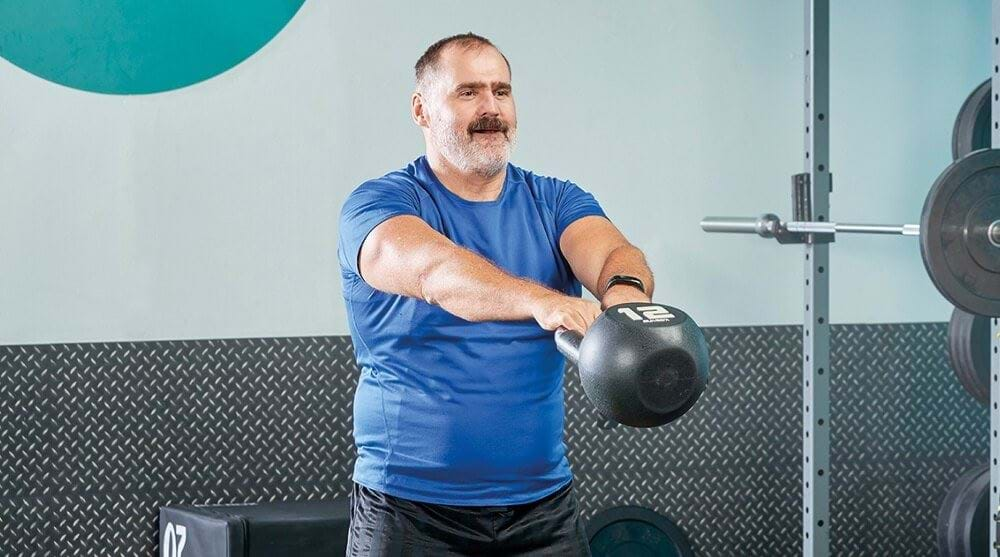 Senior man exercising with kettlebell