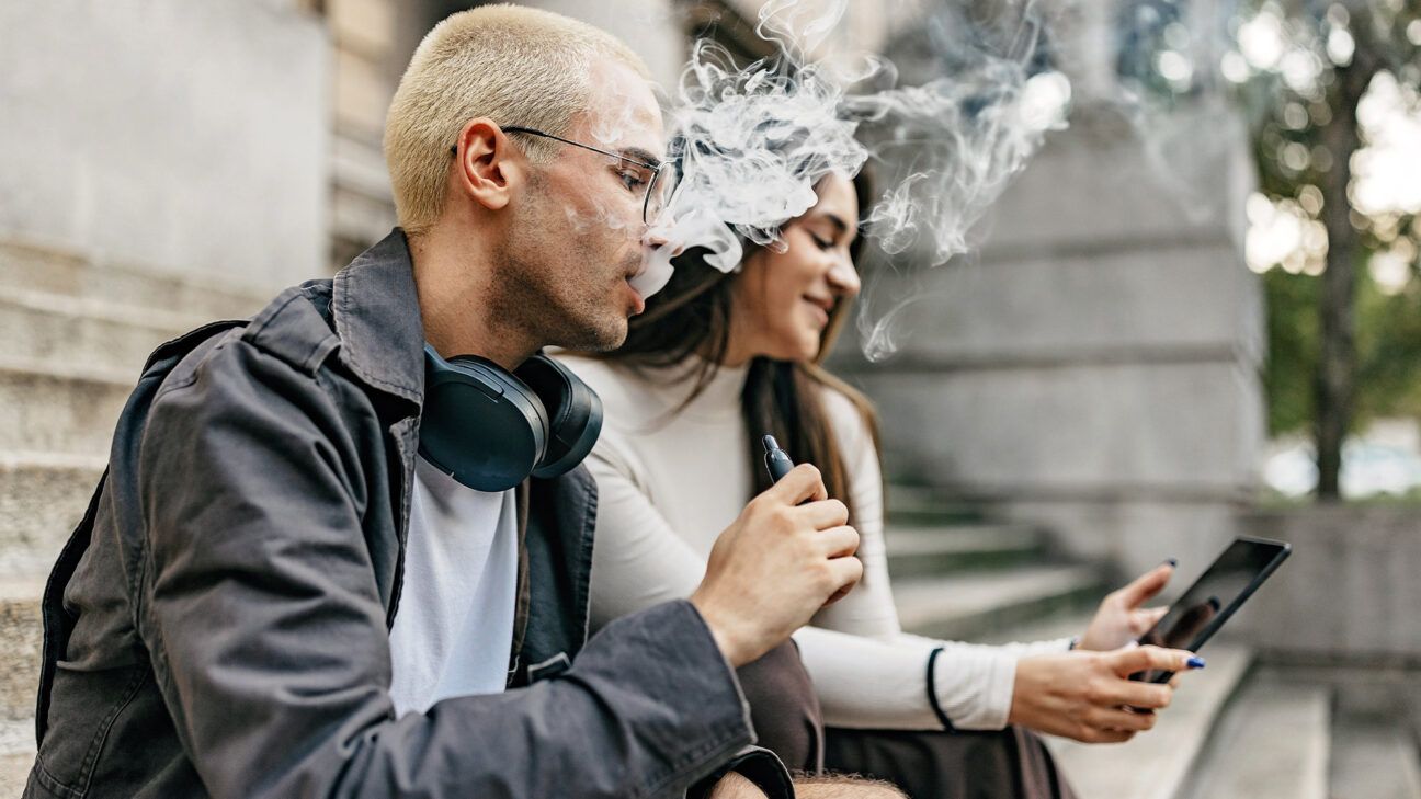 Man vaping beside woman