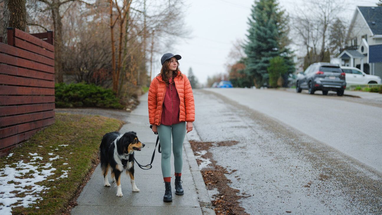 Woman walking dog in neighborhood