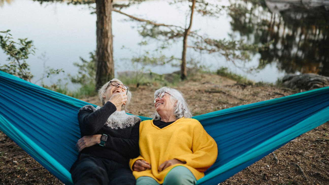 Two older women relaxing in hammock