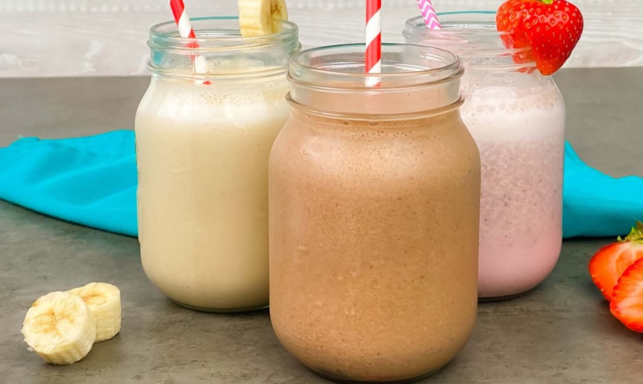 Three colorful smoothies with straws