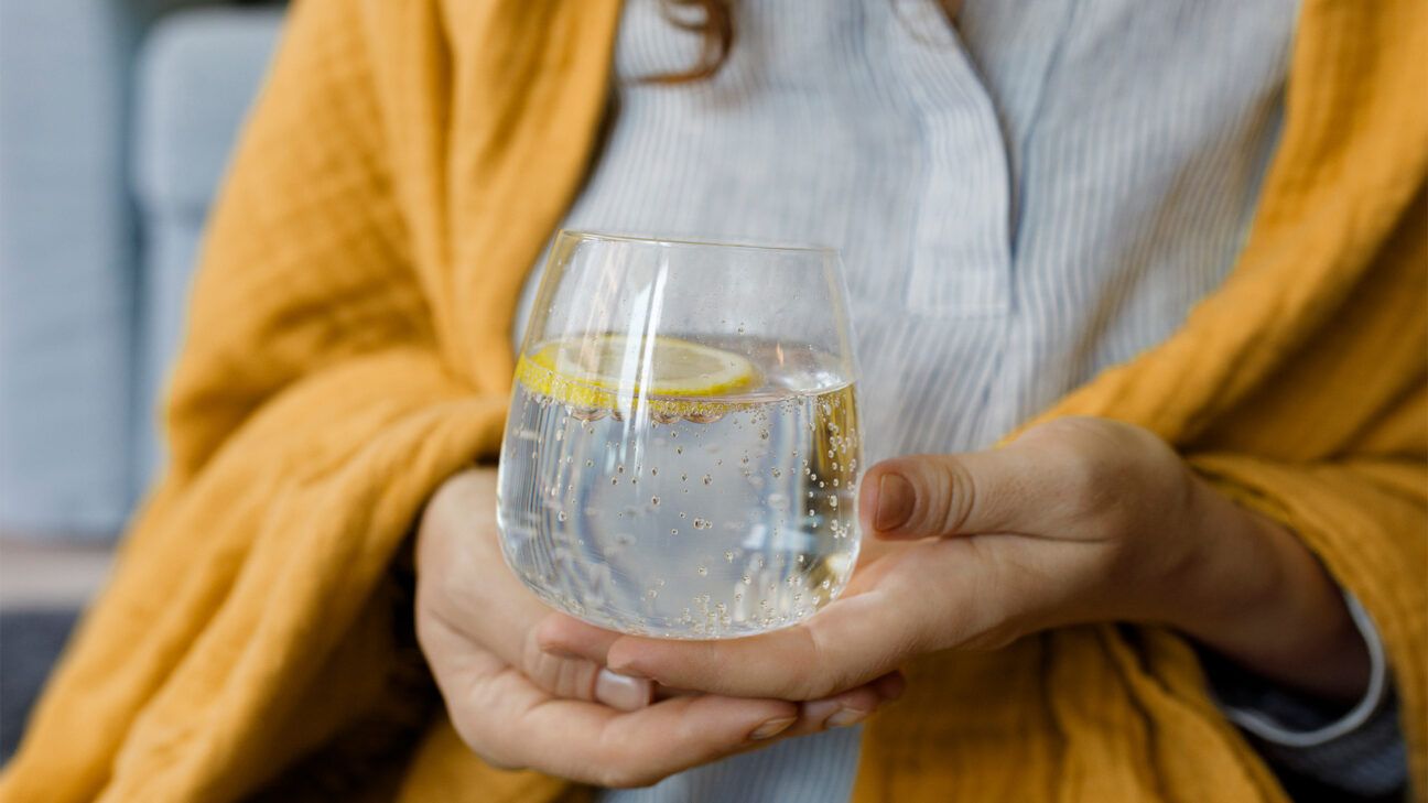 Woman holds sparkling water glass