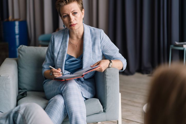 woman on couch wearing blue suit