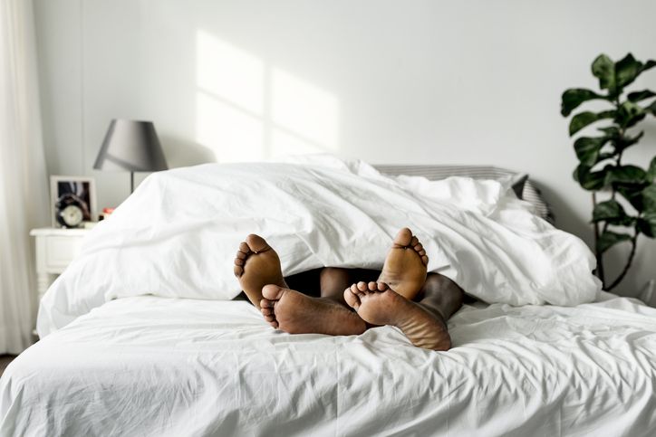 Couple sleeping peacefully under white covers