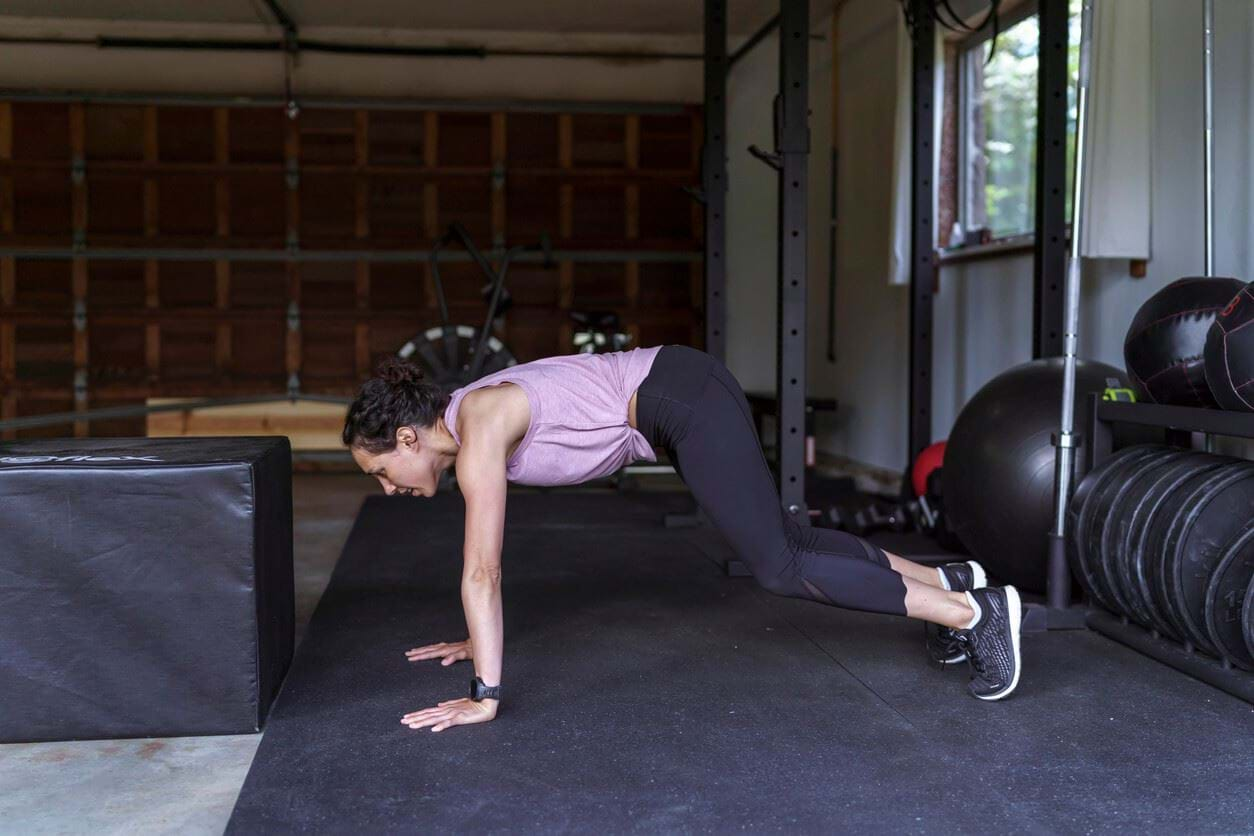 Woman performing burpee jumping jacks