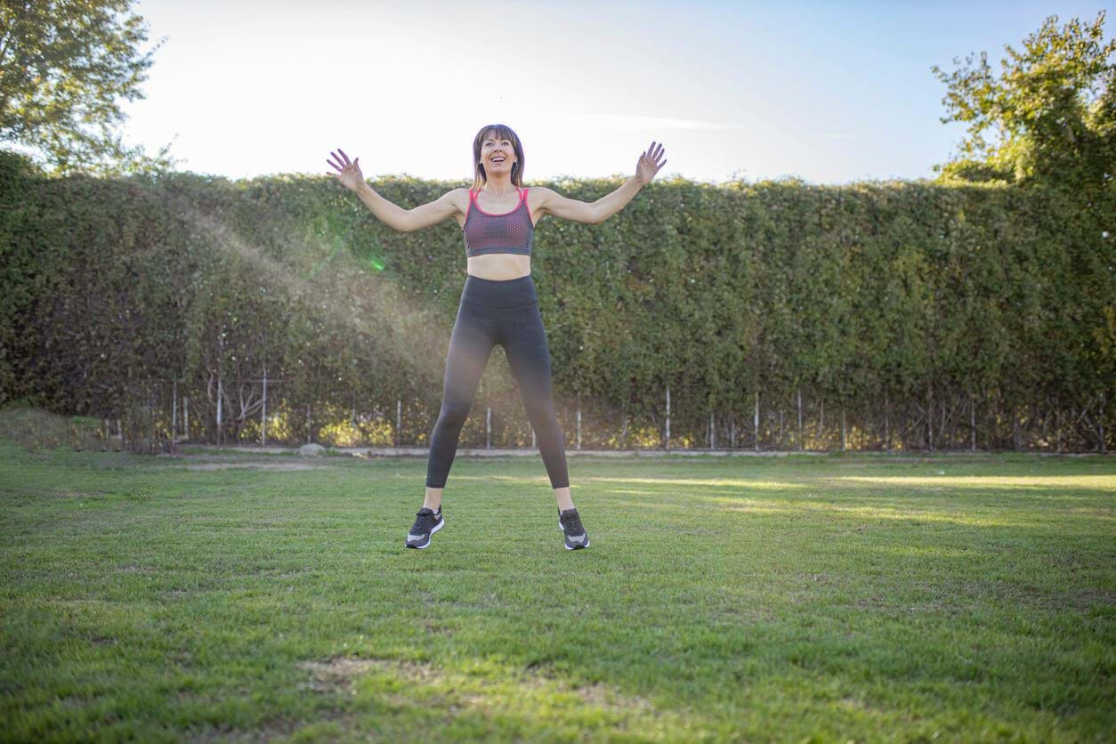 Woman performing crossover jumping jacks