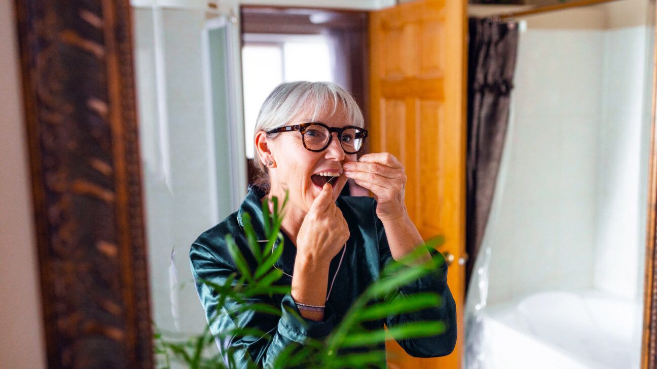 Woman flossing teeth