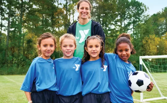 Four girls with coach in blue