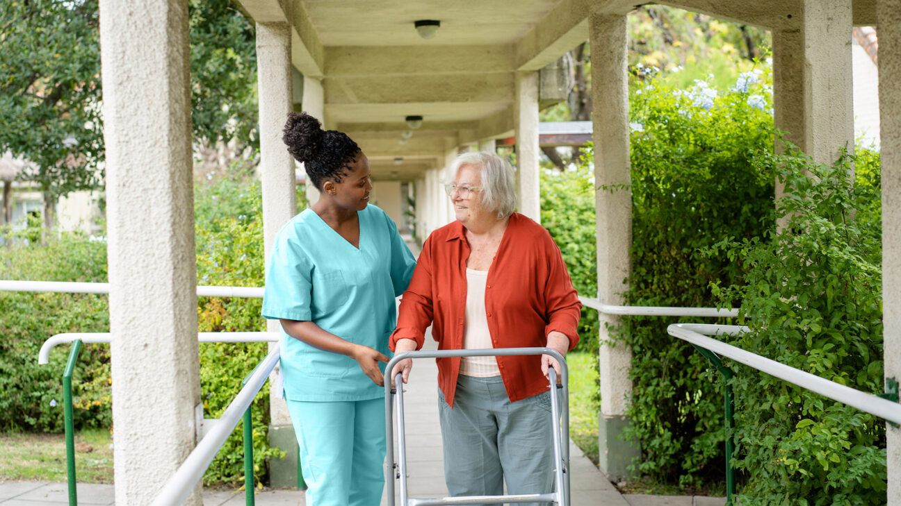 Nurse helps elderly woman walk