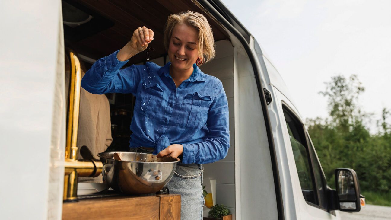 Woman seasoning food in kitchen van