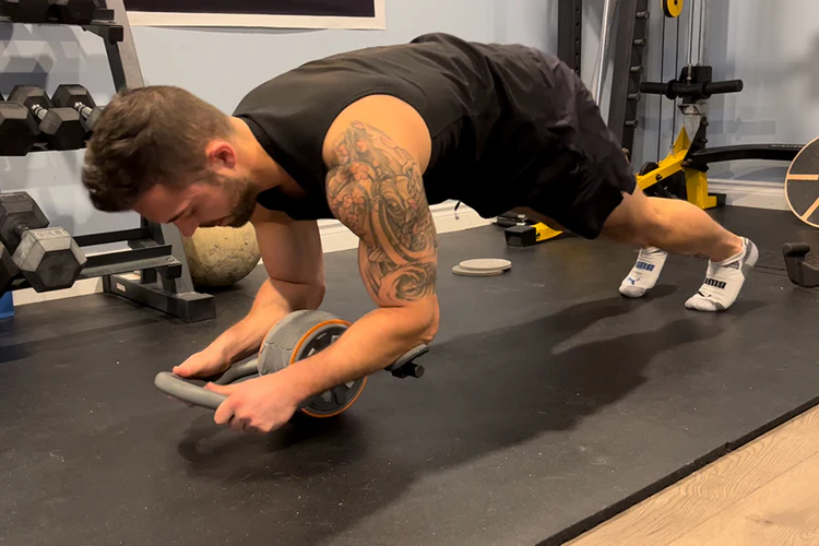 Man using ab wheel on floor