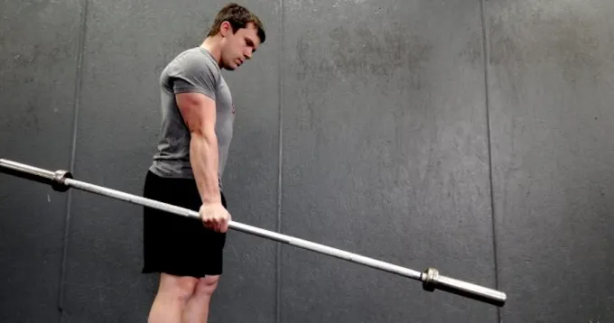 Weightlifter grips barbell during workout