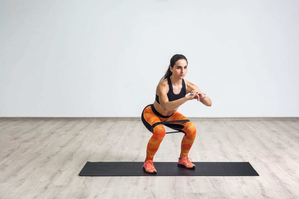 Woman squatting with resistance band