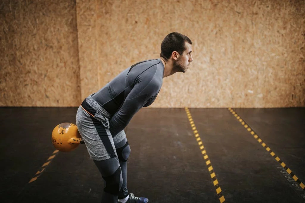 Man performing kettlebell swings