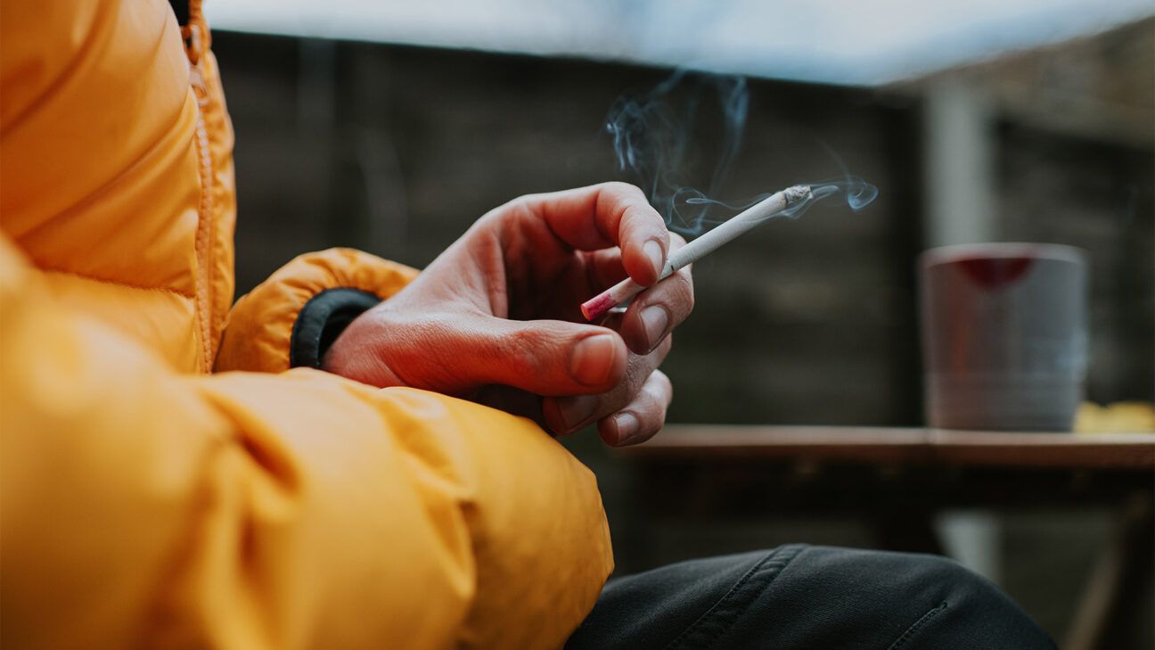 Person in puffy jacket smoking cigarette