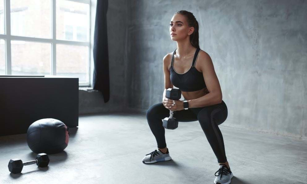 Woman doing HIIT with dumbbells