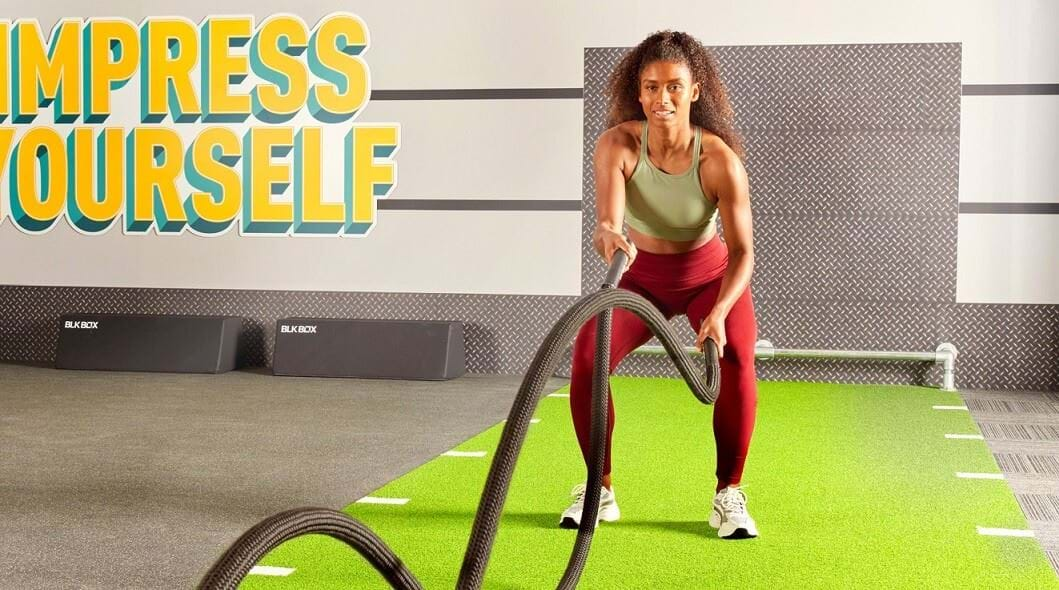 Woman using battle ropes at gym