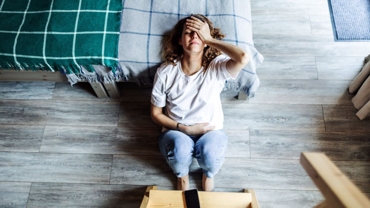 Woman holding head while sitting