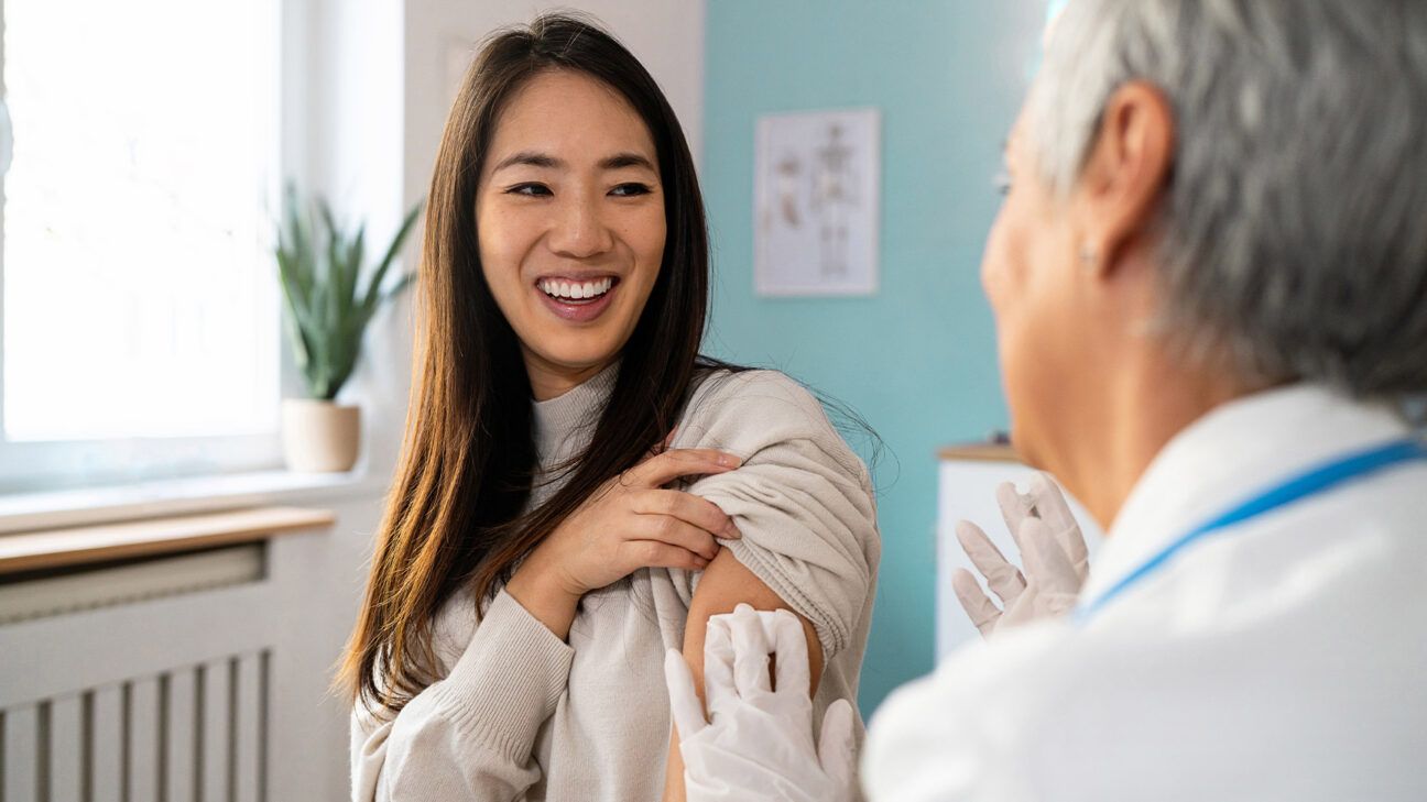 Woman receiving vaccine from doctor