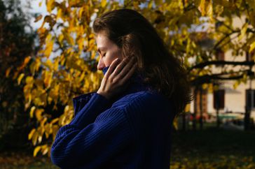 Woman praying in blue sweater