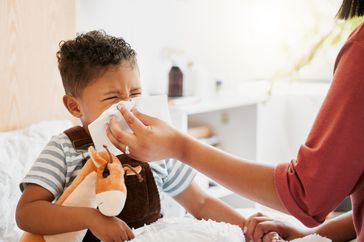 Child lying sick with flu symptoms