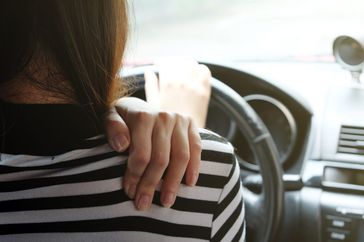 Woman sneezing while driving car