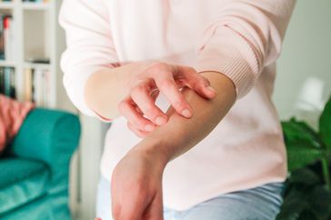 Woman scratching itchy arm