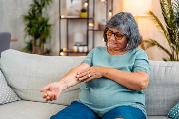 Woman scratching itchy red skin