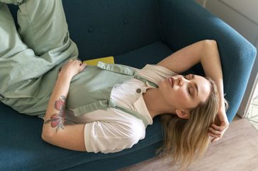 Woman napping on teal sofa